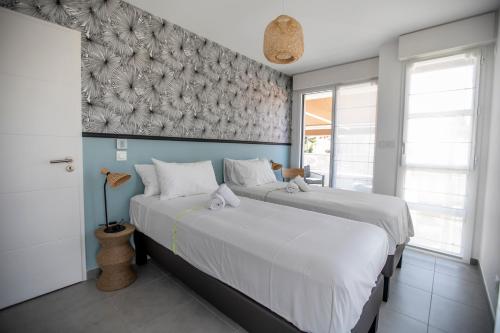 une chambre avec deux lits et une fresque murale dans l'établissement Les Terrasses De Forville by Connexion, à Cannes