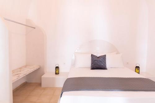a white bedroom with a bed and a staircase at Captain's house suites in Vóthon