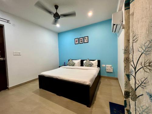 a bedroom with a bed with a blue wall at Jasmine 3BHK by Wabi Sabi Stays with Private Balcony in Rishīkesh