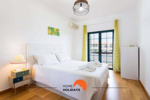 a bedroom with a white bed and a window at #146 Summer House A6 by Home Holidays in Ferreiras