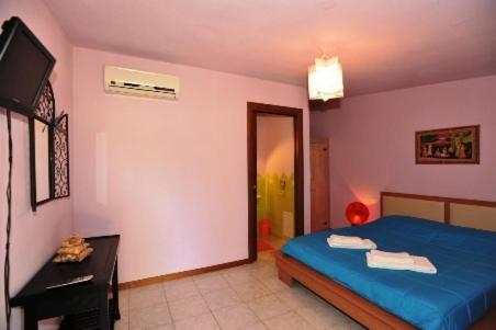 a bedroom with a blue bed and a black table at Butterfly House Bed & Breakfast in Alghero