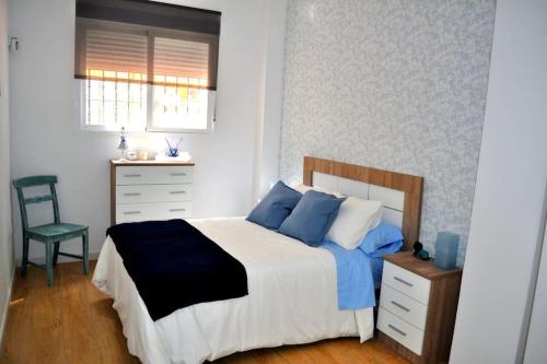 sypialnia z łóżkiem, krzesłem i oknem w obiekcie Apartamento Gran Torcal w Maladze