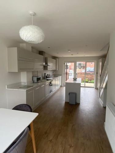 a large kitchen with white cabinets and a large window at Fruit Market Hull in Hull
