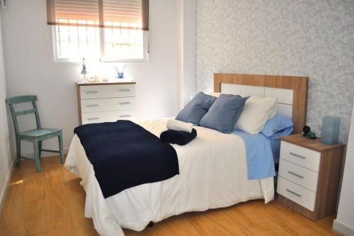 sypialnia z łóżkiem, komodą i krzesłem w obiekcie Apartamento Gran Torcal w Maladze