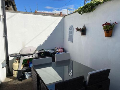 a patio with a glass table and a white wall at Terenure House in Terenure