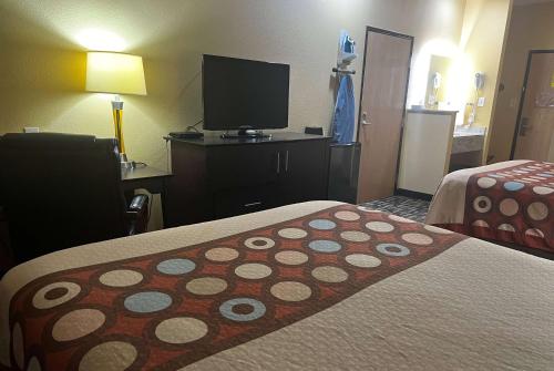 a hotel room with two beds and a flat screen tv at Super 8 by Wyndham Pasadena in Pasadena
