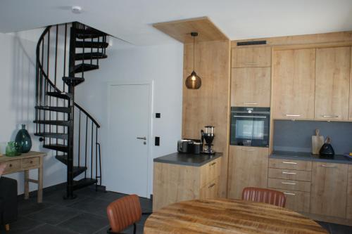 a kitchen with a spiral staircase and a table with chairs at Dock2Apartment Rügen Whg 3 großer Balkon, ruhige Lage in Lohme