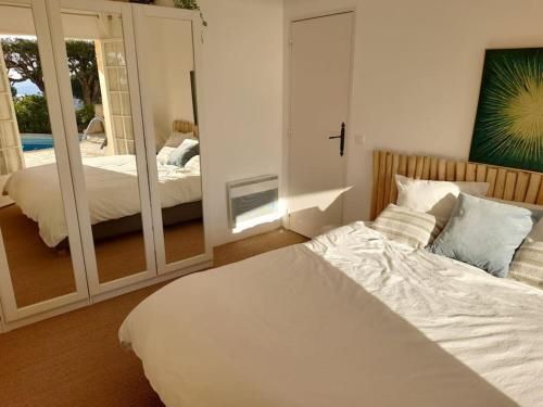 a bedroom with a white bed and a mirror at 4-Star Private Villa with Heated Pool and Panoramic Sea View at Gulf de Saint Tropez in Cavalaire-sur-Mer