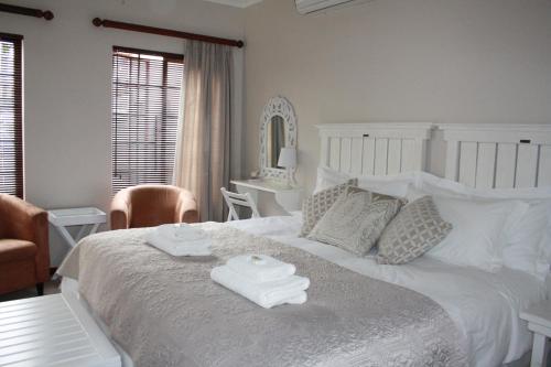 a bedroom with a white bed with two towels on it at Cozi Corner in Queenstown