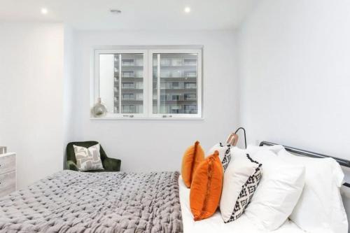 a bedroom with white walls and a bed with pillows at Cosy 2 bedroom Apartment-Zone 1 in London