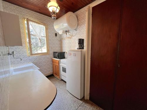 une cuisine avec un réfrigérateur blanc et une fenêtre dans l'établissement Appartement 2 pièces avec jardin privatif, proche plage et commerces, à Saint Aygulf - FR-1-226A-103, à Fréjus