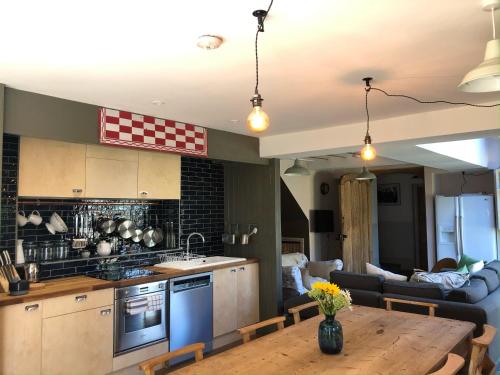 cocina y sala de estar con mesa de madera en Starnash Farmhouse Holiday Home, en Hailsham