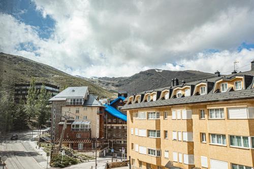 um edifício com um escorrega azul em frente a uma montanha em Holidays, Edelweiss, 1 dormitorio, 4 personas em Sierra Nevada