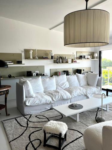 un salon avec un canapé blanc et une table dans l'établissement Très bel appartement type loft avec terrasse, quartier Saint-Augustin à Bordeaux, à Bordeaux