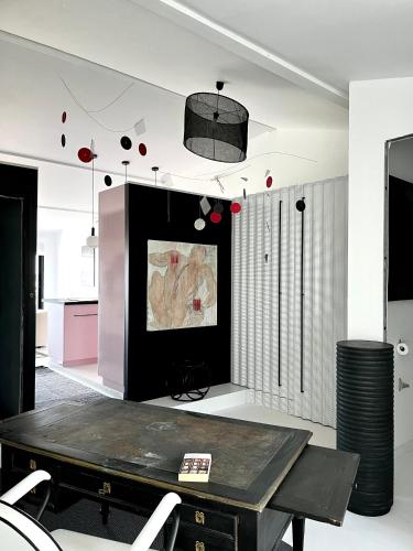 d'un salon avec une table et une peinture murale. dans l'établissement Très bel appartement type loft avec terrasse, quartier Saint-Augustin à Bordeaux, à Bordeaux