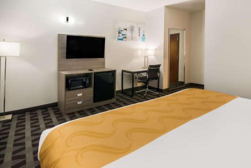 a hotel room with a bed and a flat screen tv at Quality Inn & Suites in Waco