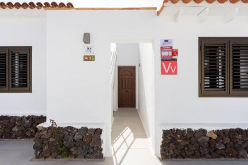 una casa blanca con un montón de leña en Joy Tenerife Charming House, en San Miguel de Abona