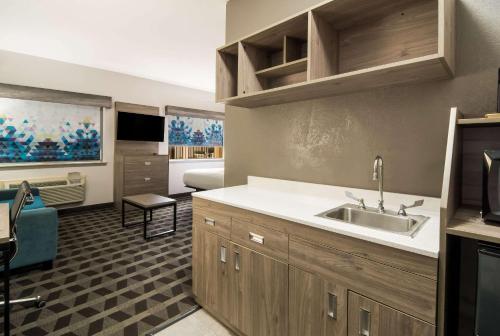 eine Küche mit einem Waschbecken und ein Wohnzimmer in der Unterkunft Quality Inn & Suites in Waco