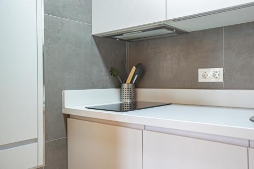 Una cocina blanca con una encimera con portacuchillos. en Acebo 2 dormitorios, en Sierra Nevada
