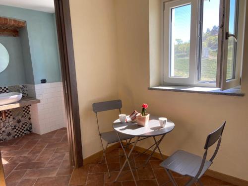 a small table and chairs in a room with a window at Casa Quinterni in Alba