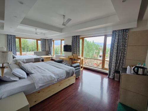 a bedroom with a large bed and a large window at Yarab Tso in Leh