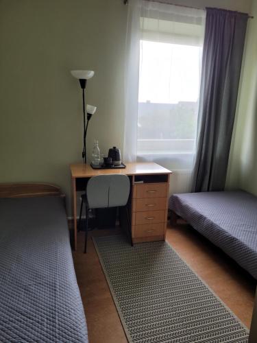 1 dormitorio con escritorio, 1 cama y ventana en Jono Pauliaus II piligrimu namai en Raseiniai