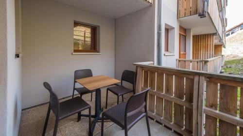 un patio avec des chaises et une table sur un balcon dans l'établissement Vacancéole - Les Etoiles d'Orion, à Orcières