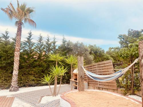 uma rede de descanso num pátio com uma palmeira em Pool Oasis with Mountain Views em Maçanet de la Selva