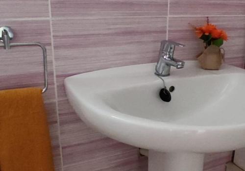 een witte wastafel in een badkamer met roze tegels bij Casa Lo Fangar - Deltebre in Deltebre