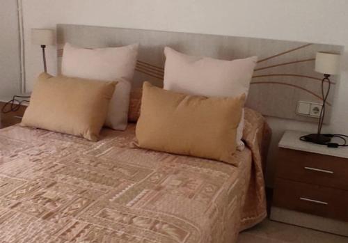 een slaapkamer met een bed met kussens en een tafel bij Casa Lo Fangar - Deltebre in Deltebre
