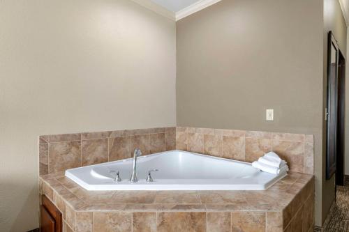 e bagno con vasca e parete piastrellata. di Comfort Inn & Suites Fort Worth - Fossil Creek a Fort Worth