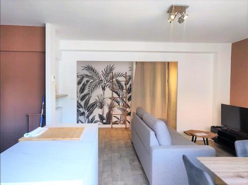 ein Wohnzimmer mit einem weißen Bett und einem Sofa in der Unterkunft Le Nogué - Idéal Couples - Charmant Cocon in Pau