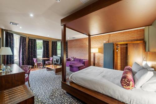 シェフィールドにあるザ ラットランド ホテルのベッドとリビングルームが備わるホテルルームです。