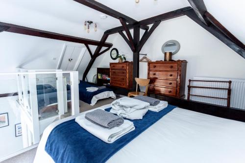 1 dormitorio con 1 cama con toallas en The Old Schoolhouse, en Whitstable