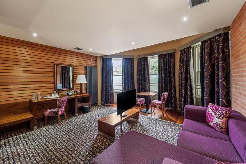 a hotel room with a purple couch and a desk at The Rutland Hotel in Sheffield