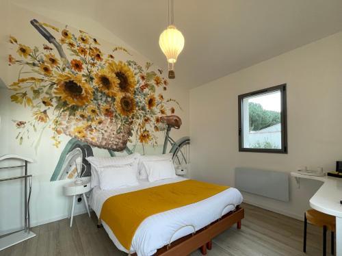 Le 36 Maison d'hôtes Piscine & Spa في مدينة لا فلوت: غرفة نوم مع سرير مع ترتيب ازهار كبير على الحائط