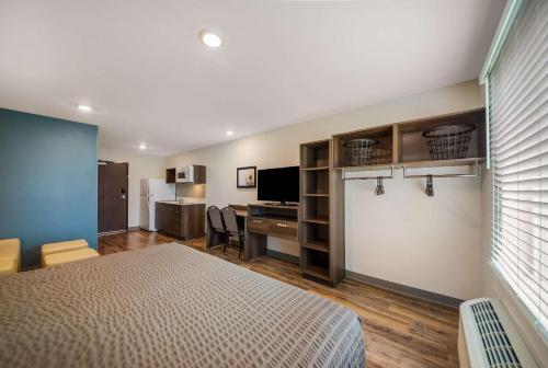 インバネスにあるWoodSpring Suites Invernessのベッドとパソコン付きの机がある寝室