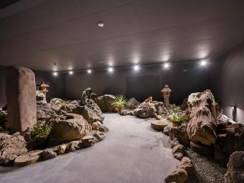 a room with rocks and plants in a room with lights at Hitoyoshi Onsen Nabeya in Hitoyoshi