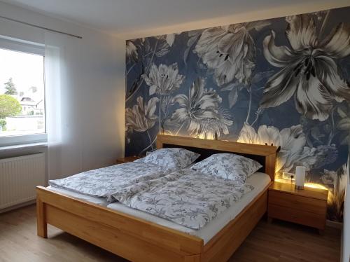 a bedroom with a bed with a floral wallpaper at Ferienwohnung Ingeborg 