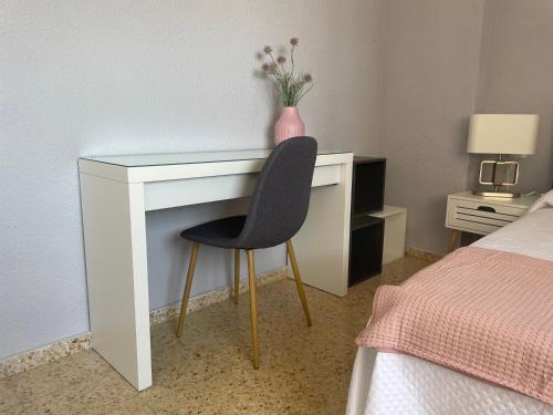 einen Schreibtisch mit einer Blumenvase darüber in der Unterkunft Apartamento 3 habitaciones con piscina y vistas al mar in Benicàssim