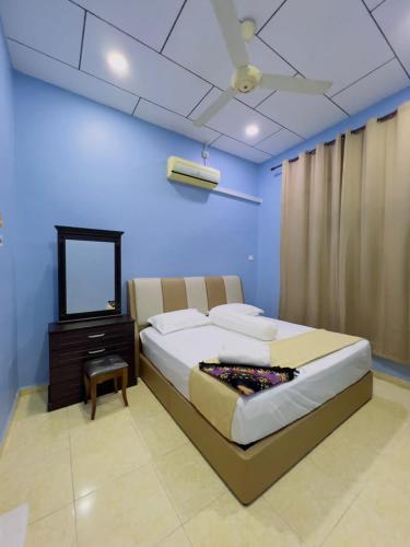 a bedroom with a large bed and a television at Sena Yang Indah Homestay in Kangar