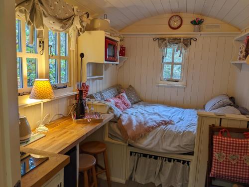 um pequeno quarto com uma cama numa pequena casa em Shepherds Hut with Hot Tub em Fryup