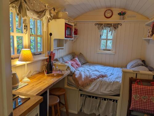 a small bedroom with a bed in a tiny house at Shepherds Hut with Hot Tub in Fryup