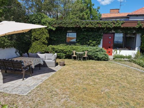 a patio with an umbrella and a table and chairs at Guest cottege in Ystad