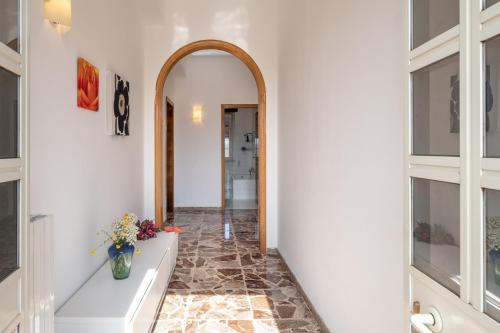 um corredor com um espelho e um vaso com flores em Casa Libeccio em Gagliano del Capo