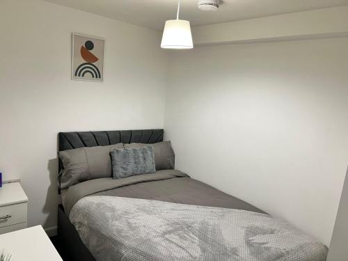 a bedroom with a bed in a white wall at Bradford Service accommodation in Bradford