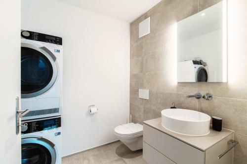 a bathroom with a washing machine and a washer and dryer at Linda Terrace by Quokka 360 - modern one-bedroom flat with sun terrace in Locarno