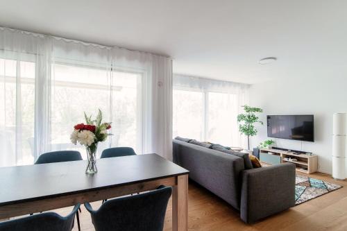 a living room with a table with a vase of flowers at Linda Terrace by Quokka 360 - modern one-bedroom flat with sun terrace in Locarno