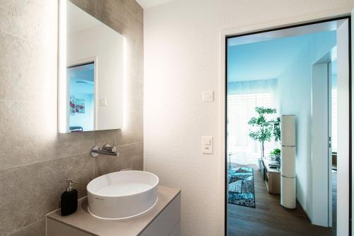 a bathroom with a white sink and a mirror at Linda Terrace by Quokka 360 - modern one-bedroom flat with sun terrace in Locarno