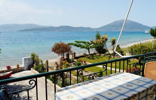 balcón con mesa y vistas al océano en EVIA DREAM FAMILY APARTMENTS en Edipsos